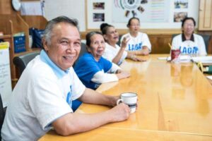 Lao community members at conference table smiling at camera