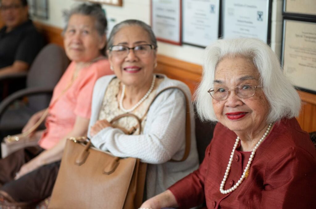 Photo of three women sitting together looking at the camera.