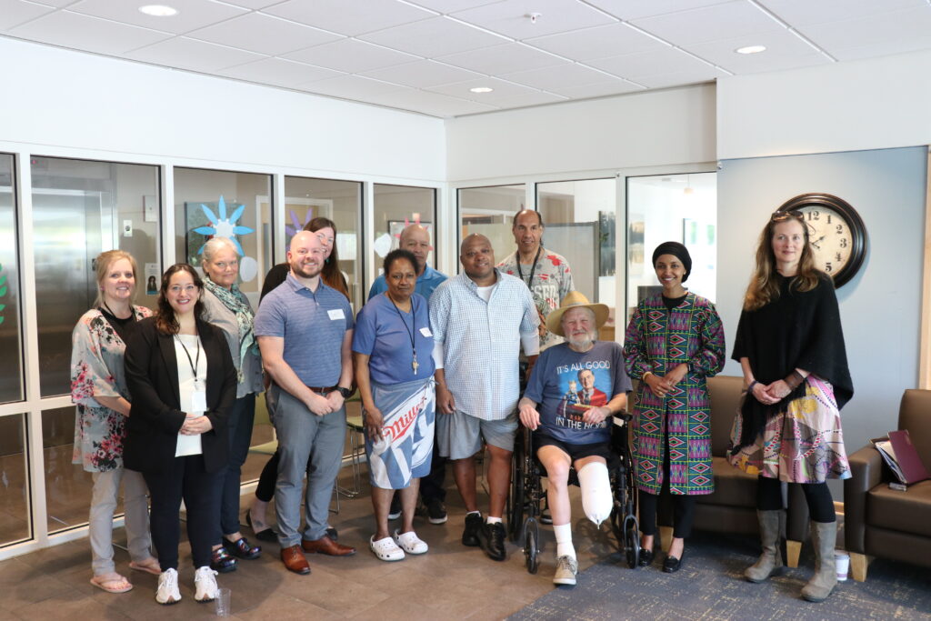 A group of eleven people posing with U.S. Representative Ilhan Omar.