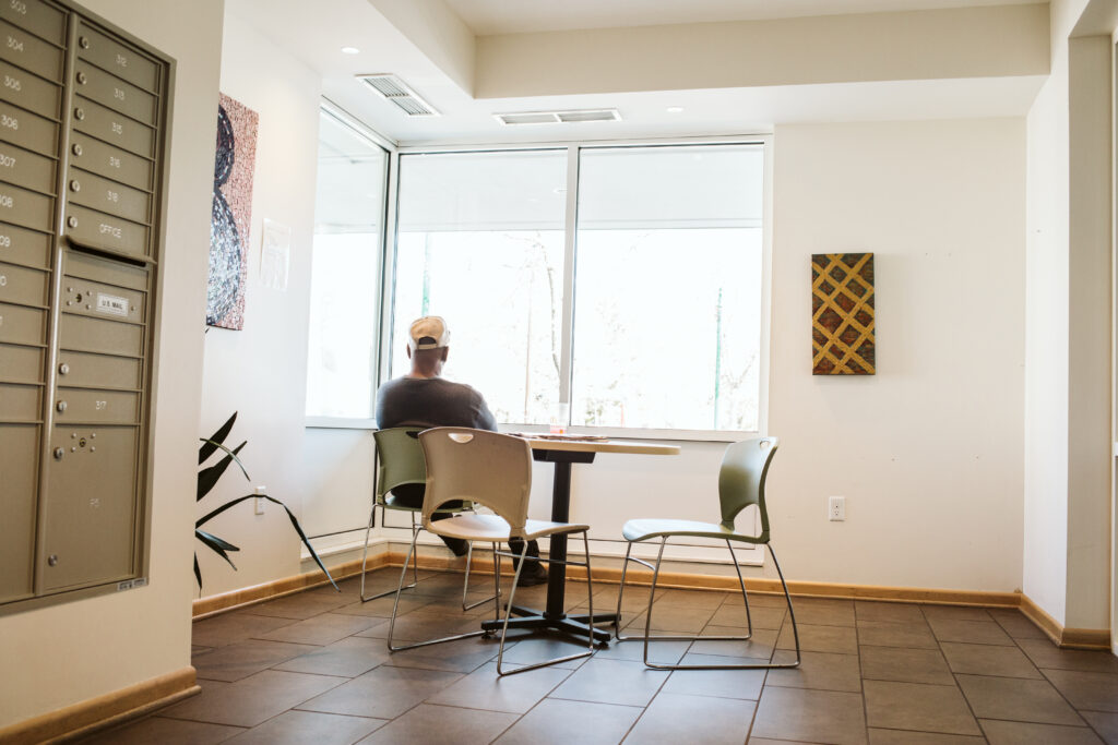 A person sitting at a table looking out a window.