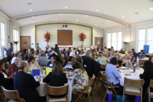 Photo of a conference room full of people seated at round tables.