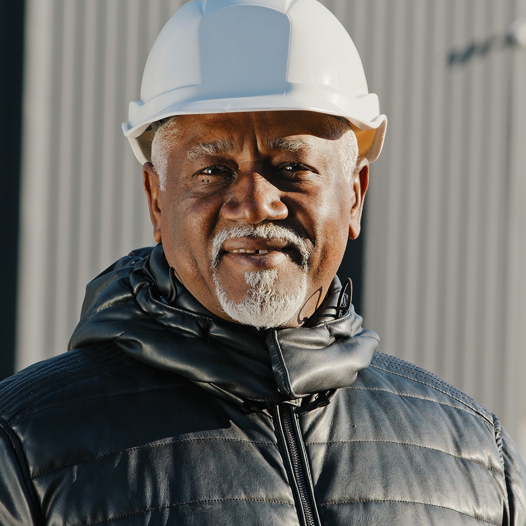 Close up photo of a person wearing a hard hat.