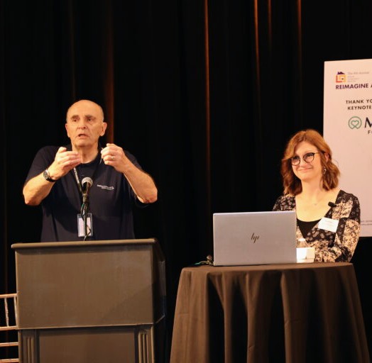 Photo of John Ward presenting on a stage.