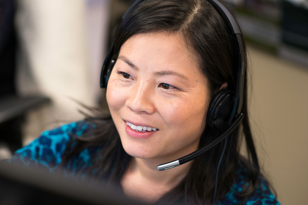 Photo of a woman speaking into a headset.