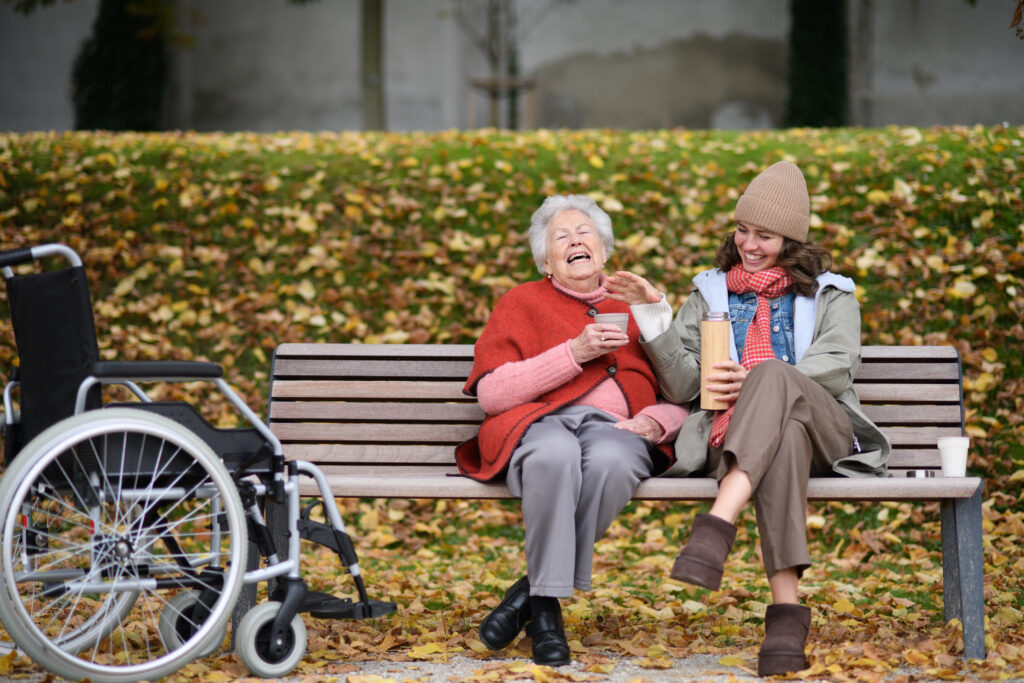 Two people sitting together on a park bench, laughing.