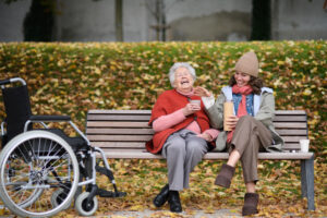 Two people sitting together on a park bench, laughing.