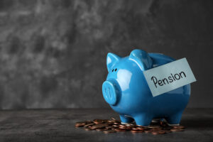 Photo of a blue piggy bank with a sticky note attached that reads "Pension."
